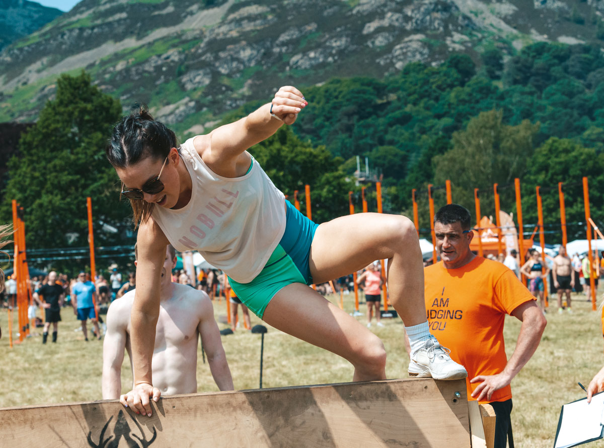The coach is jumping across an obstacle.